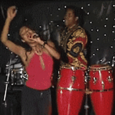 Woman In Red Dress Singing Into Microphone On Stage GIF