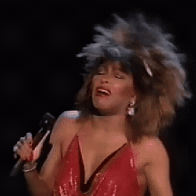 Woman In Red Dress Singing Into Microphone While Dancing GIF
