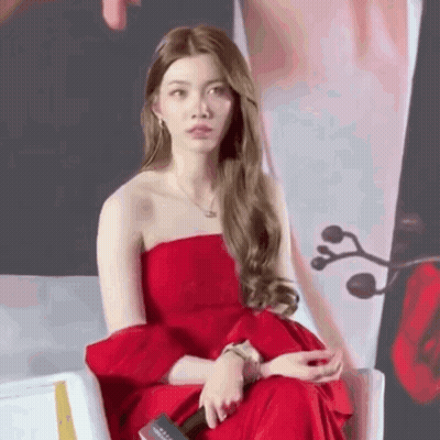 Woman In Red Dress Sitting With Microphone GIF