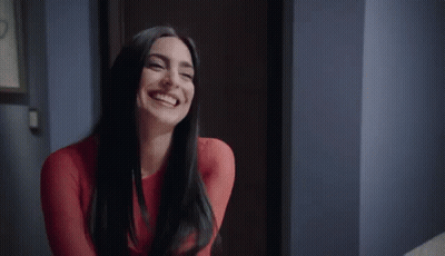 Woman In Red Dress Smiling And Laughing In Hallway GIF