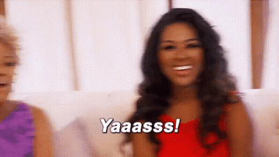 Woman In Red Dress Smiling While Another Says Yaaass GIF