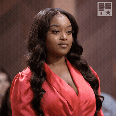 Woman In Red Dress Standing In Front Of Bet Logo GIF
