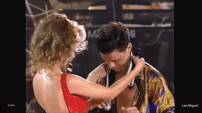 Woman In Red Dress Touching Man's Neck GIF