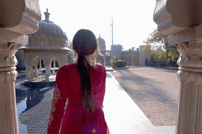 Woman In Red Dress Walking By Building GIF