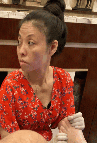 Woman In Red Floral Shirt Getting Manicure GIF