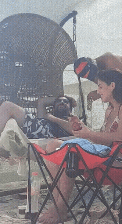 Woman In Red Folding Chair Beside Man GIF