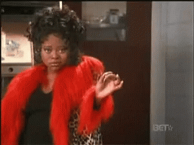 Woman In Red Fur Coat Standing In Front Of BET TV Sign GIF