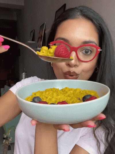 Woman In Red Glasses Holding Bowl Of Oatmeal With Berries GIF