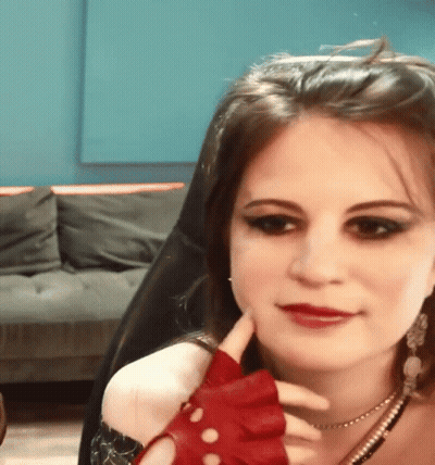 Woman In Red Gloves Sitting With Chin On Hand GIF
