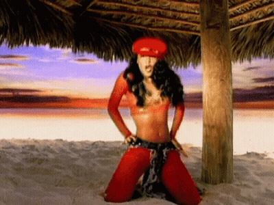 Woman In Red Hat Kneeling On Beach GIF