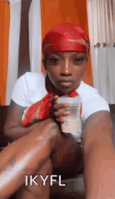 Woman In Red Headband Sitting On Couch Holding Cup GIF