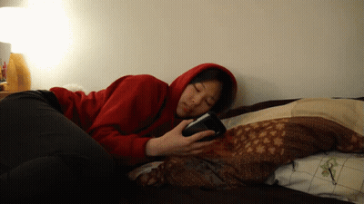 Woman in Red Hoodie on Phone in Bed