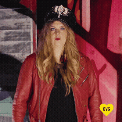 Woman In Red Jacket And Black Hat With Yellow Heart Saying BG GIF