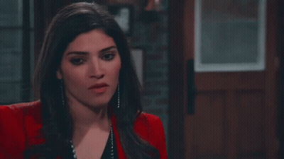 Woman In Red Jacket And Black Top Standing Before Door GIF