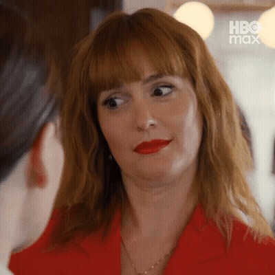 Woman In Red Jacket And Red Lipstick Looking At Woman GIF