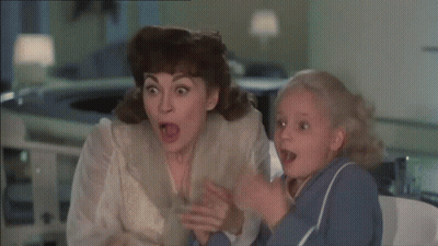 Woman In Red Jacket Sitting By Old Radio GIF