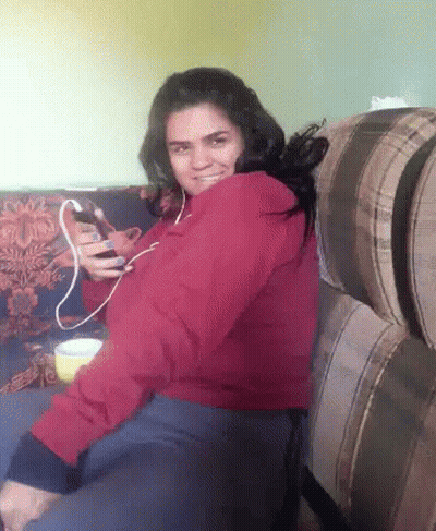 Woman In Red Jacket Sitting On Couch GIF