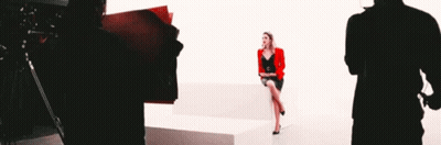 Woman In Red Jacket Sitting On White Couch GIF