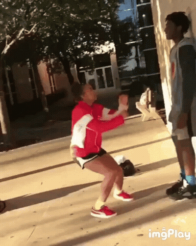 Woman In Red Jacket Squatting On Sidewalk GIF