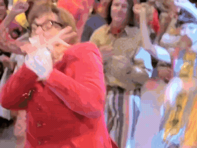 Woman In Red Jacket Standing Before Crowd GIF
