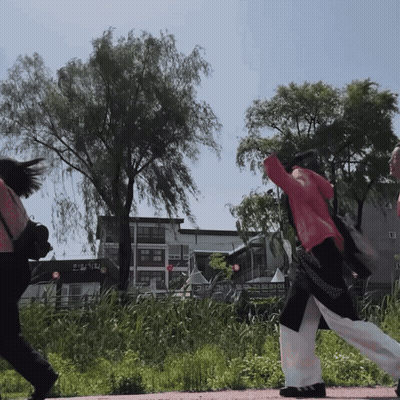 Woman In Red Jacket Walking Past Korean Sign GIF