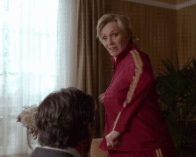 Woman In Red Jacket With Yellow Stripes Next To Man In Suit GIF