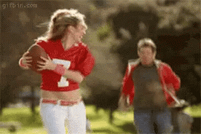 Woman In Red Jersey Number 1 Holding Football GIF