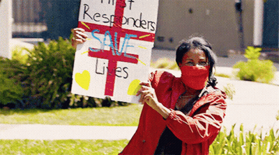 Woman In Red Mask Holding Save Lives Sign GIF