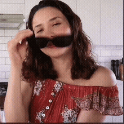 Woman In Red Off-Shoulder Top Covering Face With Sunglasses GIF
