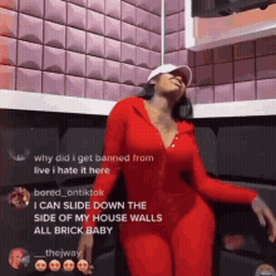 Woman In Red Outfit Dancing In Front Of Brick Wall GIF