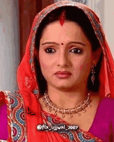 Woman In Red Scarf And Necklace Looking At Camera GIF