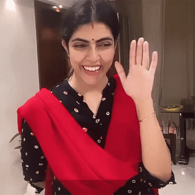 Woman In Red Scarf Smiling And Waving GIF
