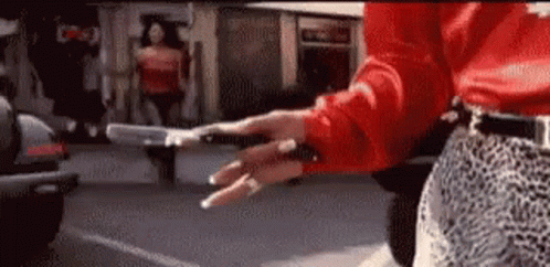 Woman In Red Shirt And Leopard Skirt Holding Gun GIF