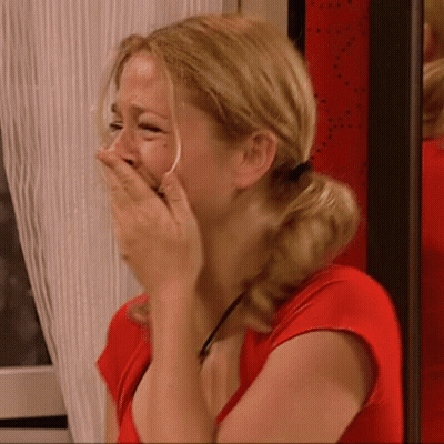 Woman In Red Shirt Covering Face With Hands GIF