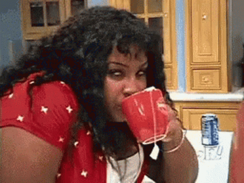 Woman In Red Shirt Drinking From Red Cup GIF