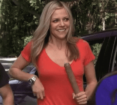 Woman in Red Shirt Holding Bat and Smiling
