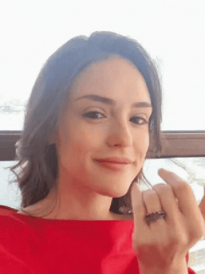 Woman In Red Shirt Looking At Camera GIF