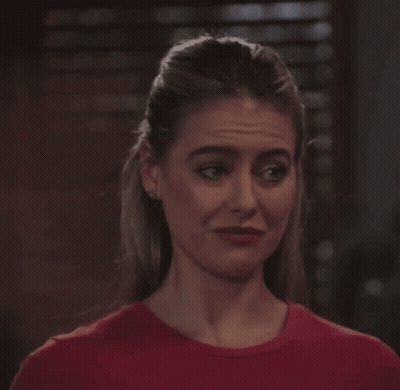 Woman In Red Shirt Looking At Camera GIF