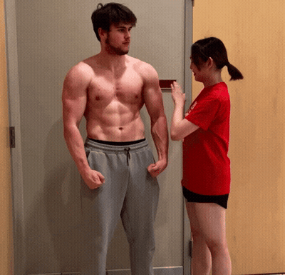 Woman In Red Shirt Measuring Man's Arm GIF