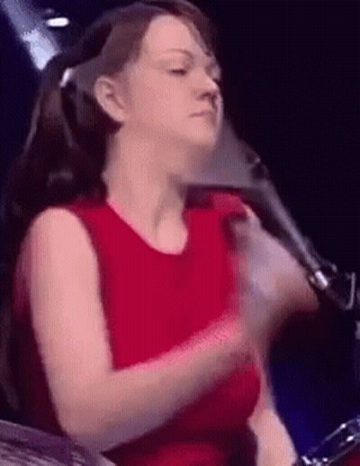 Woman in Red Shirt Playing Drum Set