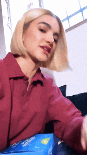 Woman In Red Shirt Sitting On Couch With Candy GIF