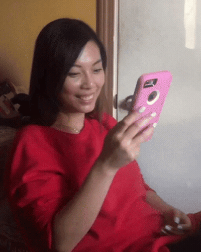 Woman In Red Shirt Smiling Holding Pink Phone GIF