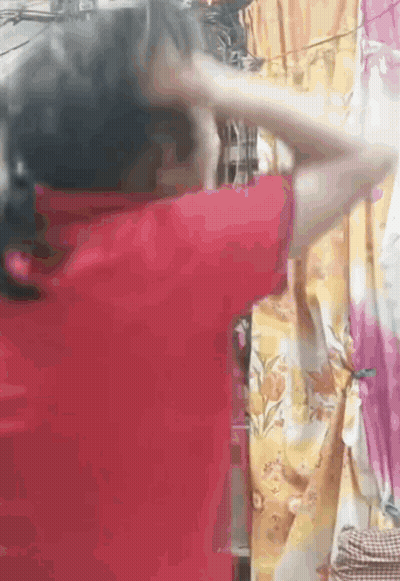 Woman In Red Shirt Standing Before Curtain GIF