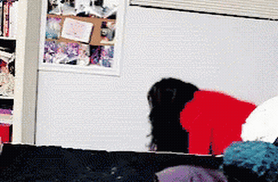 Woman In Red Shirt Standing By Bookshelf GIF