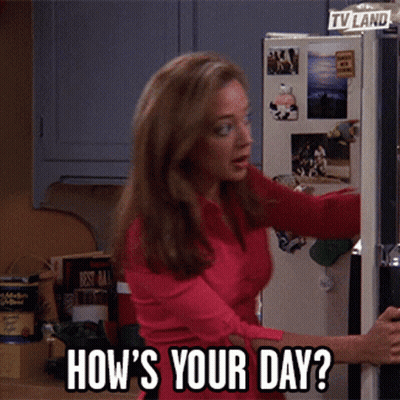 Woman In Red Shirt Standing In Front Of Refrigerator Saying How's Your Day GIF