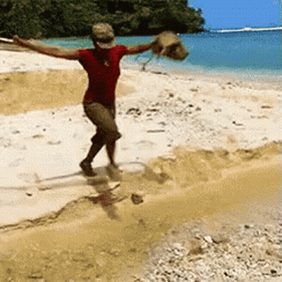Woman In Red Shirt Standing On Beach GIF