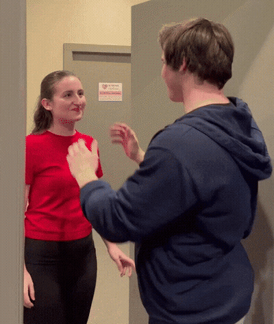 Woman In Red Shirt Talking To Man In Blue Hoodie GIF
