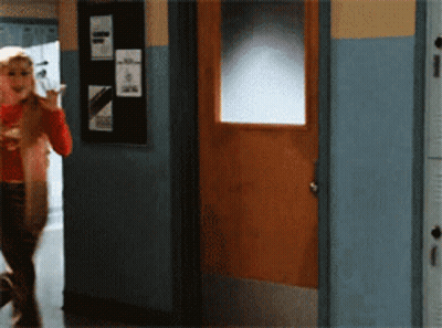 Woman In Red Shirt Walking To Wooden Door GIF