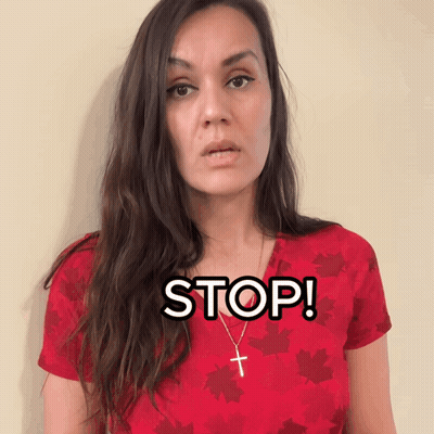 Woman In Red Shirt With Maple Leaves And Cross Necklace Says Stop GIF
