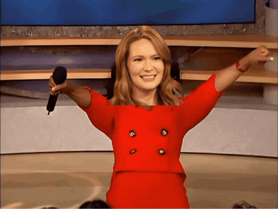 Woman in Red Suit Holding Microphone and Smiling